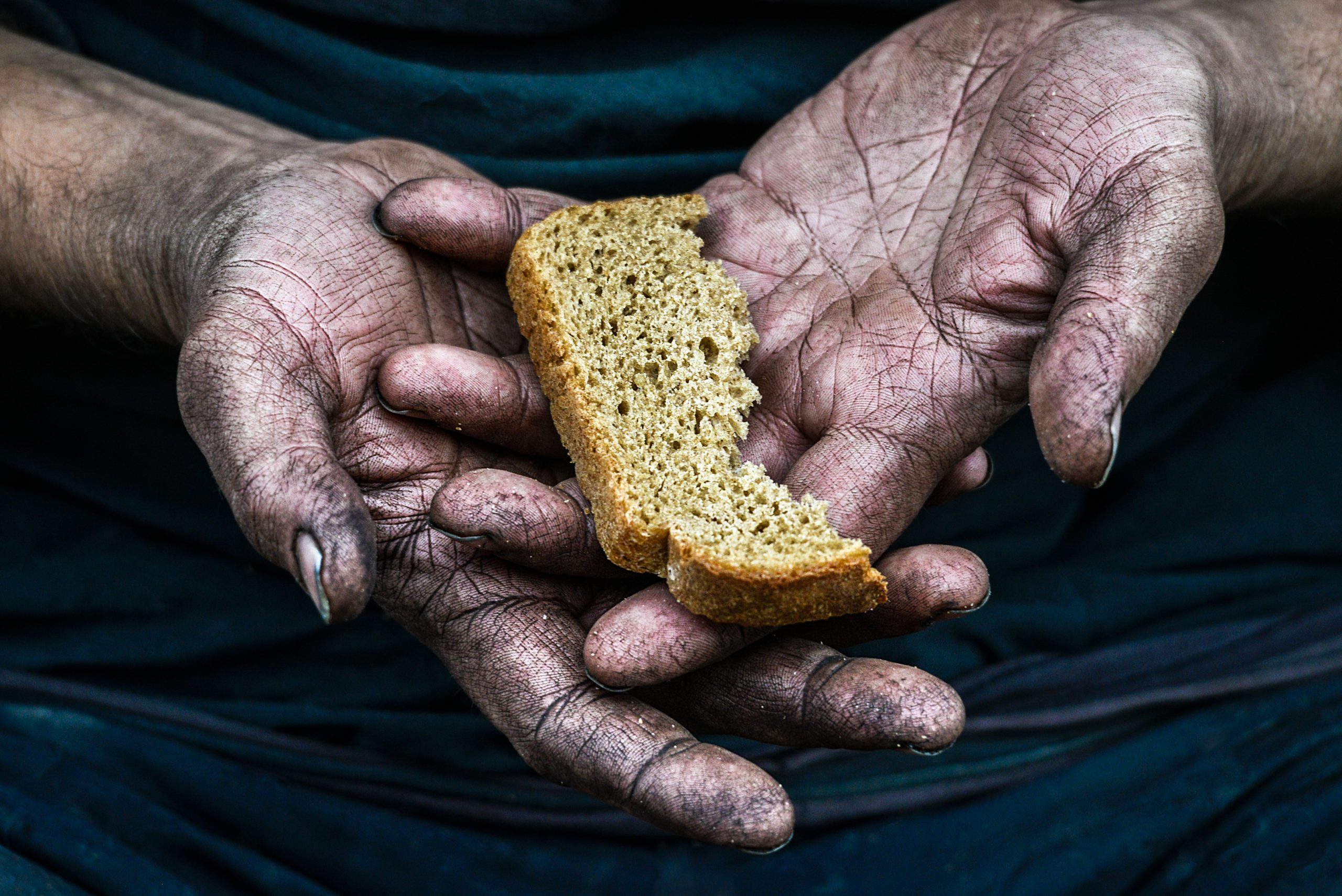 Голод осень. Кусок хлеба в руке. Хлеб в руках. Бедность хлеб.
